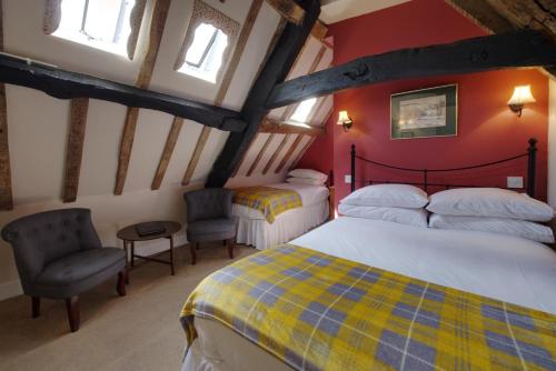 赛伦塞斯特科里尼翁酒店及餐厅的阁楼上的卧室配有2张床和2把椅子