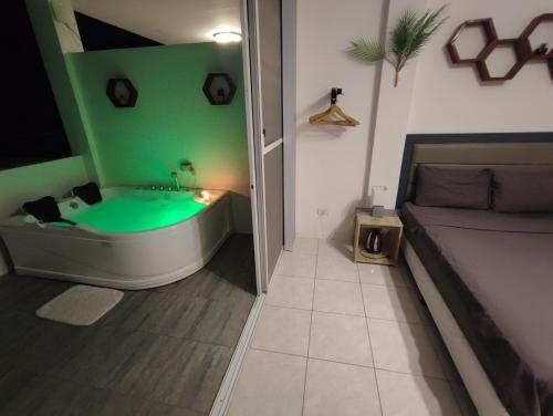 邦劳Bonsai Jacuzzi Suites的一间带绿色浴缸和沙发的浴室