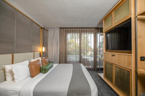 内罗毕The Social House Nairobi, a Preferred Lifestyle Hotel的一间卧室配有一张床和一台平面电视