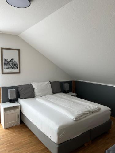 巴特温普芬New Age Boardinghaus Bad Wimpfen的一间卧室配有一张带2个床头柜和2盏灯的床。
