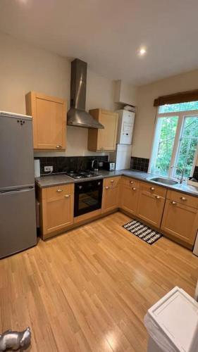 伦敦1 bed flat in the heart of London的厨房铺有木地板,配有不锈钢冰箱。