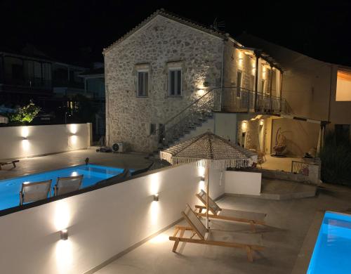 梅加尼西岛Mangata suites homes with private pools的夜间带游泳池的别墅