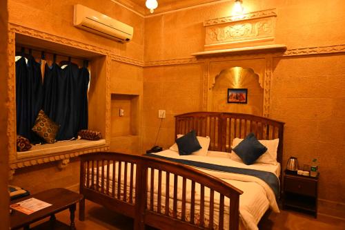 斋沙默尔Hotel Navodaya Jaisalmer的一间卧室配有一张带木制床头板的床