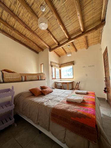普尔马马尔卡Las Lavandas Purmamarca的一间卧室设有一张带木制天花板的大床