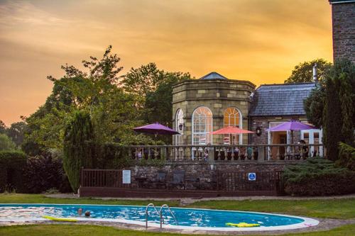 布雷肯彼特斯通苑乡间别墅餐厅及Spa酒店的一座房子前面设有游泳池