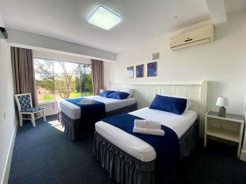 恩卡纳西翁Hotel Renty Beach的酒店客房设有两张床和窗户。
