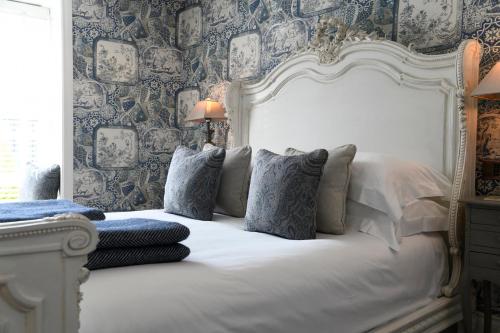 帕兹托Padstow Townhouse的卧室配有白色的床铺和蓝色的壁纸