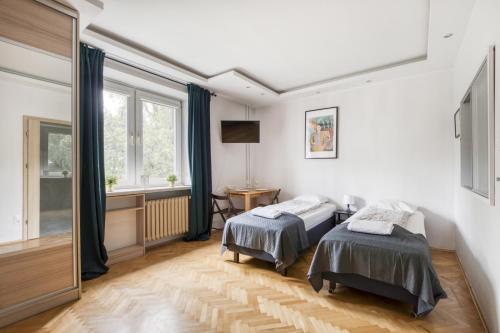 华沙Labo Apartment Ogrodowa的一间卧室设有两张床和窗户。
