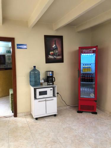 波帕扬HOTEL TORRELUZ PLAZA的配有炉灶的客房内的古柯可乐冰箱