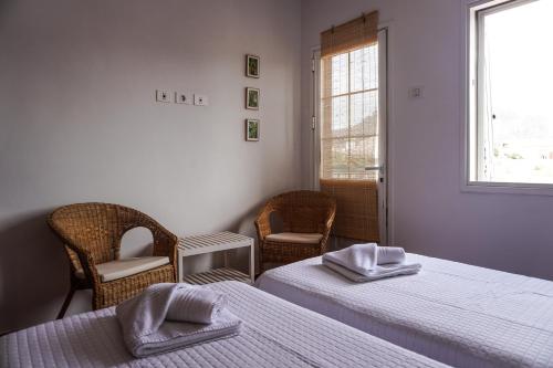 拉拉古纳Cozy Apartment in La Laguna的客房设有两张床、椅子和窗户。
