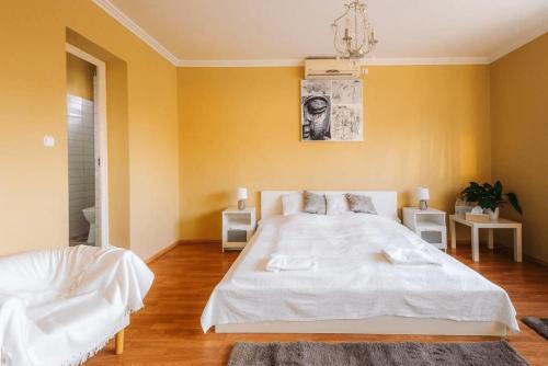绍尔特沃德凯特Páva Panzió的卧室配有白色的床和黄色的墙壁