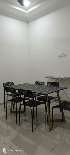 昔加末RWA Segamat homestay的白色墙壁的房间里摆放着桌椅