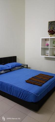 昔加末RWA Segamat homestay的一间卧室配有一张带蓝色棉被的床