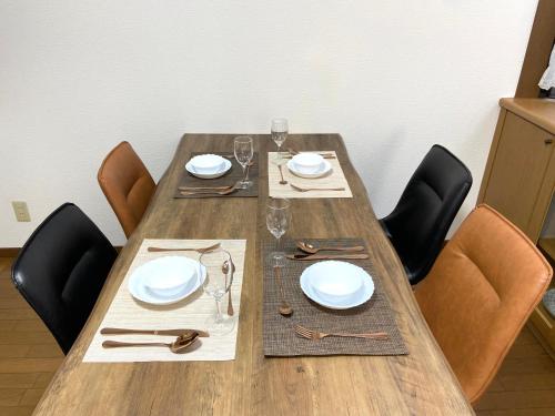 高松浜町小院别馆的一张木桌,配有椅子和盘子,酒杯