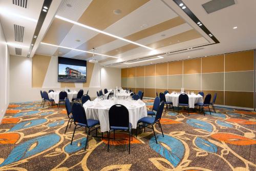 布里斯班卡拉姆维尔套房和会议中心酒店的一间会议室,配有桌椅和投影屏幕