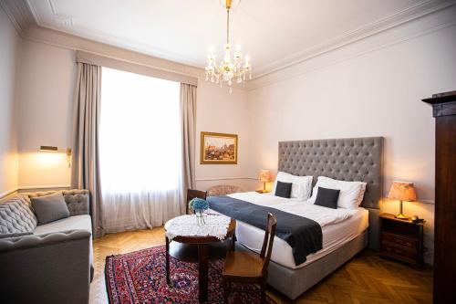维也纳Boutique Hotel Nossek的一间卧室配有一张大床和一张沙发