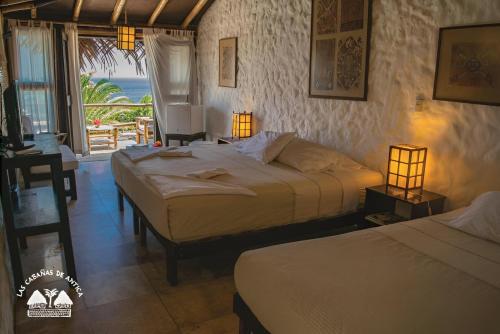 维加伊托Las Cabañas de Antica的一间带两张床的卧室,享有海景