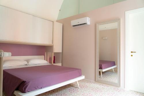 巴列塔Le tre rondini的一间卧室配有一张床和镜子