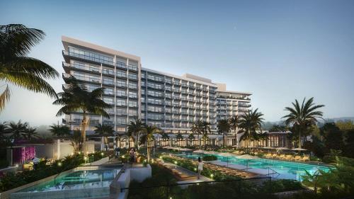Grand CaymanHotel Indigo Grand Cayman, an IHG Hotel的一座带游泳池和棕榈树的大型建筑