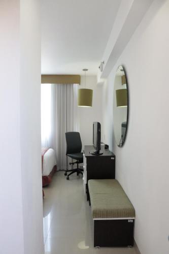 伊拉普阿托Hotel México Plaza Irapuato的酒店客房配有书桌、床和镜子