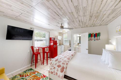 马拉松Citrus Room的一间卧室配有一张床,厨房配有红色橱柜