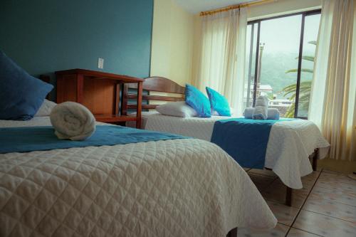 巴尼奥斯Hostal CañaLimeña的酒店客房设有两张床和窗户。