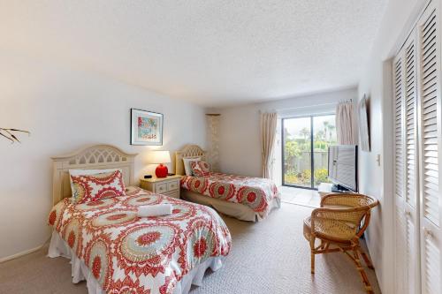 霍姆斯海滩West Bay Point 12的一间卧室配有两张床和电视