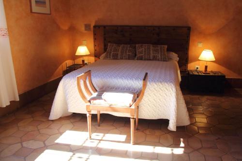 阿雷纳斯德圣佩德罗拉布雷斯康迪萨宾馆的一间卧室配有一张带椅子的床和两盏灯。
