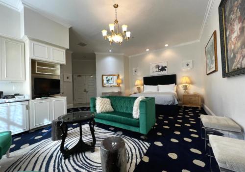 萨克拉门托Sterling Hotel的客厅配有床和绿色沙发
