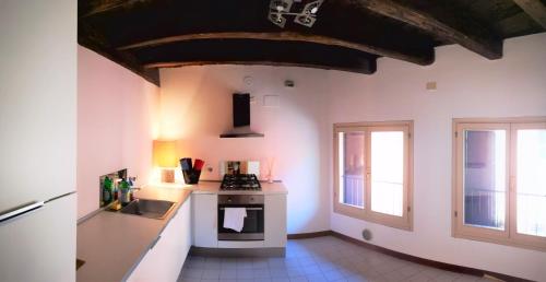博洛尼亚De' Pepoli Rooms & Apartments的厨房配有水槽和炉灶 顶部烤箱