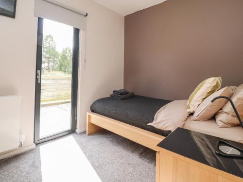康福斯Underfell的一间卧室设有一张床和一个滑动玻璃门