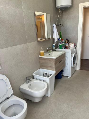 都拉斯Lukas Apartament Vollga Durres的浴室配有卫生间、盥洗盆和洗衣机。