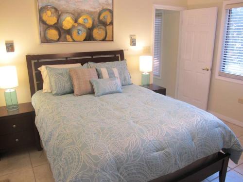 西湾Fabulous one bedroom in West Bay的一间卧室配有一张大床、枕头和两盏灯。