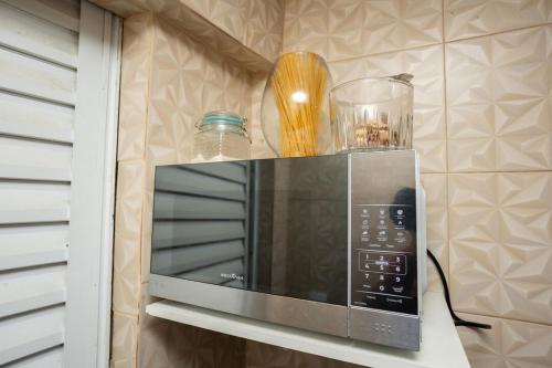 圣特雷莎Otima casa com Wi-Fi em Santa Teresa ES的厨房里的微波炉放在架子上