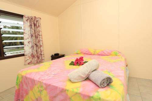 阿鲁坦加拉尼纽伊日落别墅的一张带两条毛巾的床,上面有花