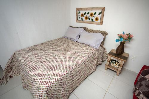 圣特雷莎Loft c localizacao perfeita e WiFi-Santa Teresa ES的一间卧室,配有一张床和花瓶