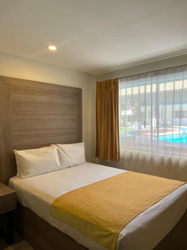 埃莫西约布吉姆比利亚酒店的一间卧室设有一张大床和窗户