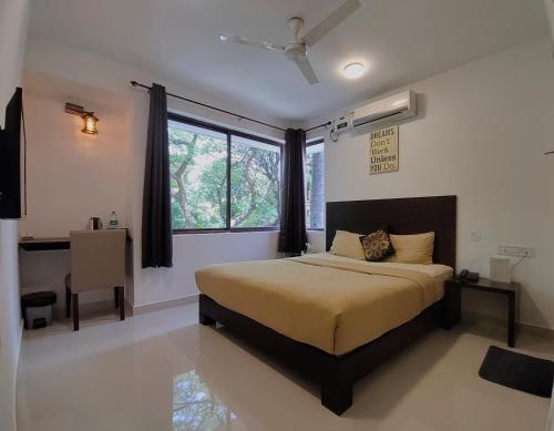 班加罗尔The Royal Living I Indiranagar的一间卧室设有一张大床和一个窗户。