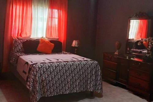 BambooHill View Villas的一间卧室配有一张带红色窗帘的床和梳妆台