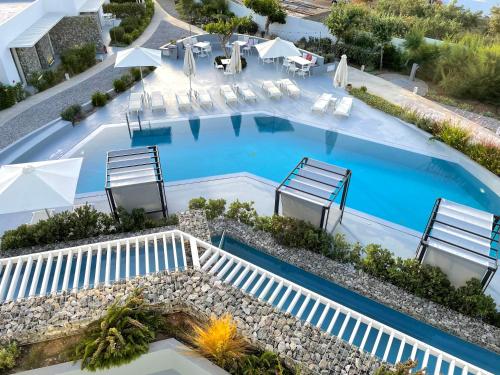 伊奥斯乔拉Relux Ios Hotel的享有带椅子和遮阳伞的游泳池的上方景色