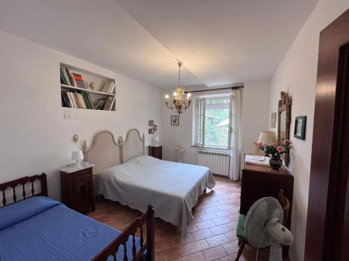 福利亚Tenuta Poggio alla Farnia的一间卧室配有两张床和吊灯。