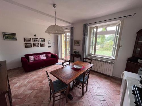 福利亚Tenuta Poggio alla Farnia的客厅配有木桌和红色沙发