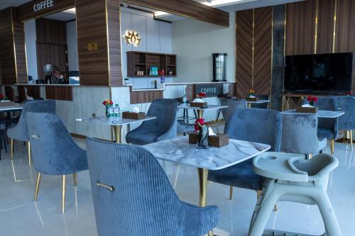 Umm al Khashabأزهار النرجس للشقق الفندقية的一间配备有蓝色椅子和桌子的用餐室