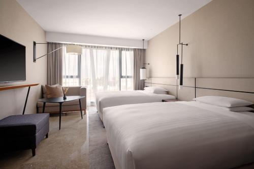 突尼斯Tunis Marriott Hotel的酒店客房设有两张床和一台平面电视。
