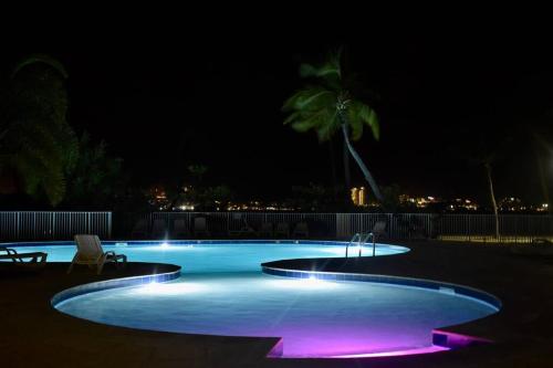 Baie NettleAppartement Seacret的游泳池在晚上点亮,紫色灯