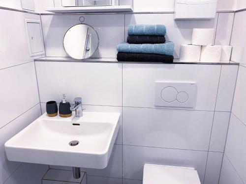 布吕尔NOVA Apartment- Phantasialand I Köln I Bonn的浴室配有盥洗盆、镜子和毛巾