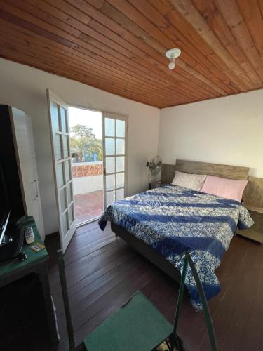 巴拉德尔楚VIRAMAR en Alvorada的一间卧室设有一张床和一个滑动玻璃门