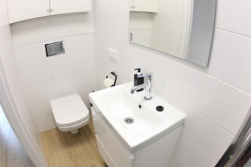 热舒夫Komfi Dom 4的白色的浴室设有水槽和卫生间。