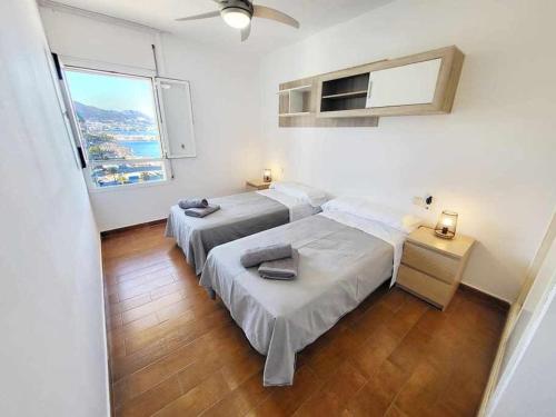 福恩吉罗拉Europa Beach House Vistas panorámicas al mar的带大窗户的客房内的两张床