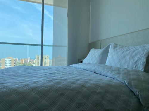 巴兰基亚Apartaestudio DISTRITO 90的一间卧室设有一张大床和大窗户